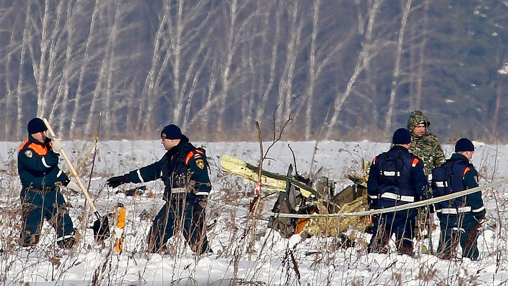 Räddningsarbetare arbetar vid platsen där det ryska flygplanet kraschade på söndagen.