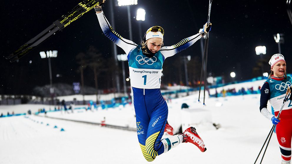 Stina Nilsson hoppar med skidorna i handen