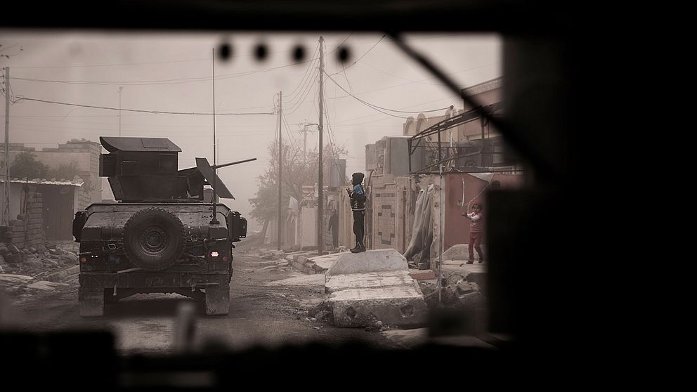 En pojke gör honnör mot de irakiska soldaterna när vi passerar.