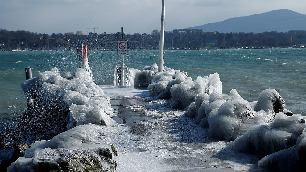 En istäckt pir vid sjön Leman i Genève i Schweiz.