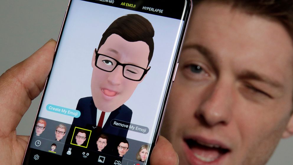 Mobiltelefon med app som gör om ditt ansikte till en emoji.