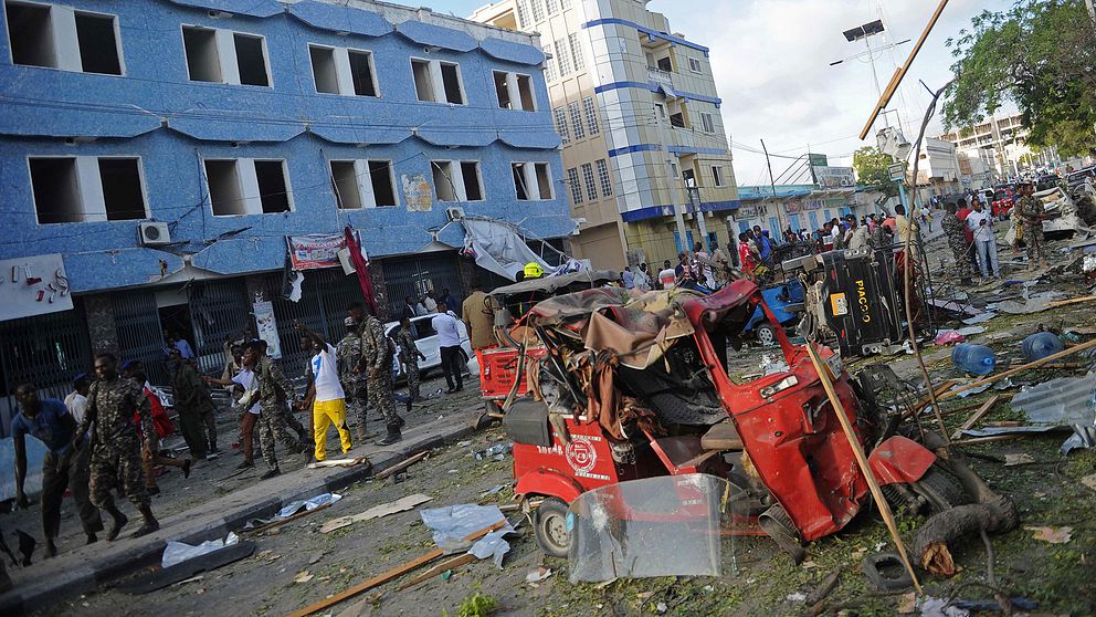Människor samlas på gatan utanför hotell Weheliye i Mogadishu, där en bilbomb kostade minst 14 människor livet på torsdagen.