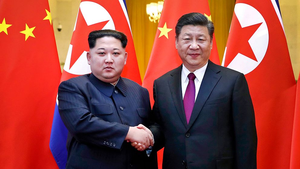 Nordkoreas diktator Kim Jong-un skakar hand med Kinas president Xi Jinping under ett möte i Peking, i slutet av mars 2018
