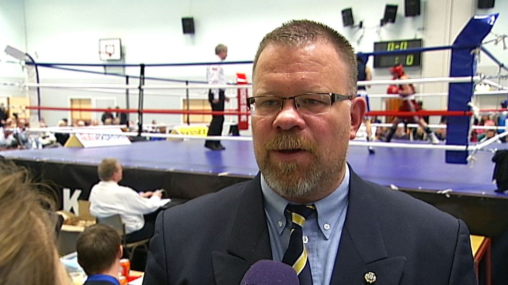 Anders Holmberg tittar snett förbi kamerab, i bakgrunden syns en boxningsring
