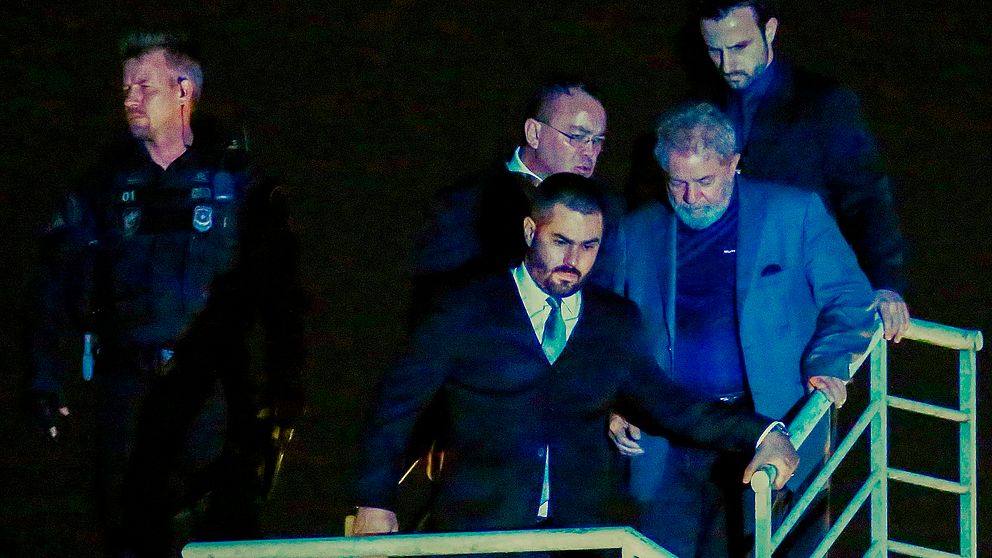 Lula da Silva överlämnade sig själv och anlände till polisen (iförd grå kostym) under lördagen.