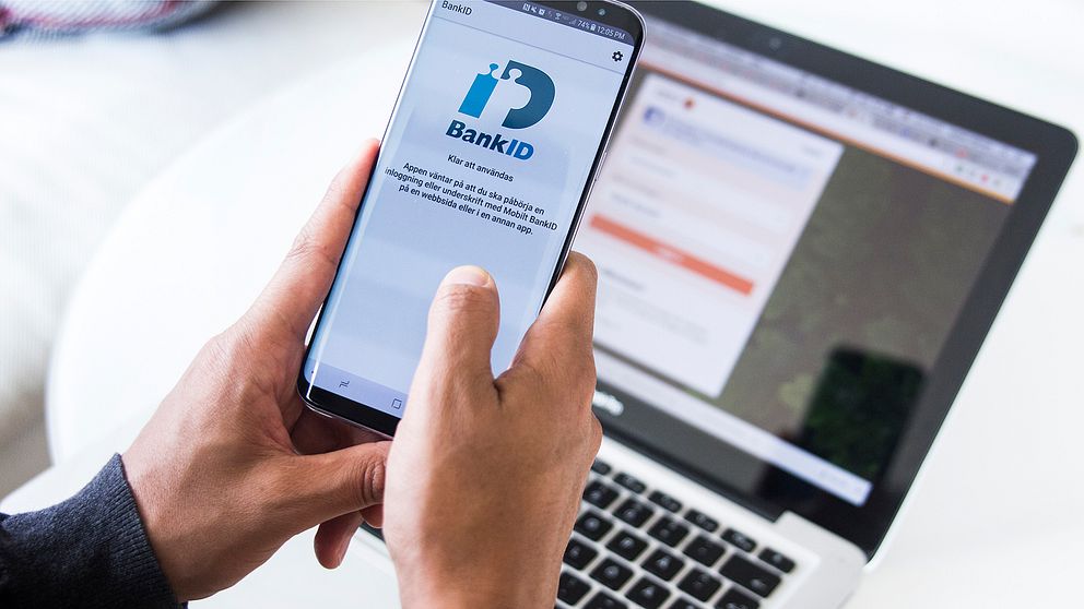 En man loggar in på sitt bank-id på mobilen