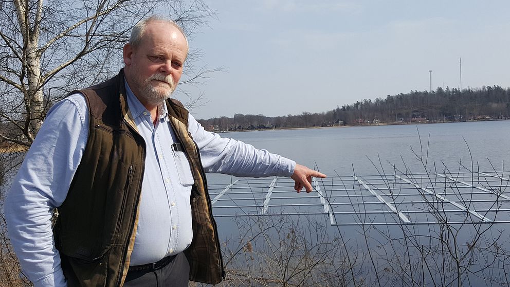 Agne Andersson pekar på plattor i sjön.