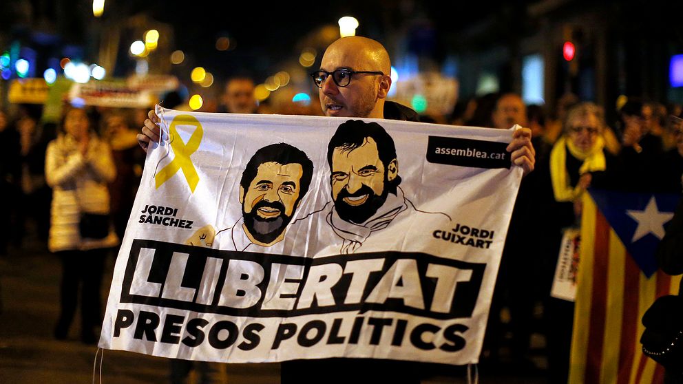 En demonstrant håller upp en bild på Jordi Sanchez och Jordi Cuixart, till stöd för de två fängslade katalanska ledarna.