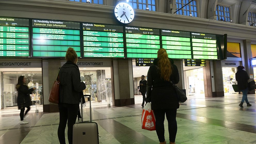 Personer som väntar på en tågstation.