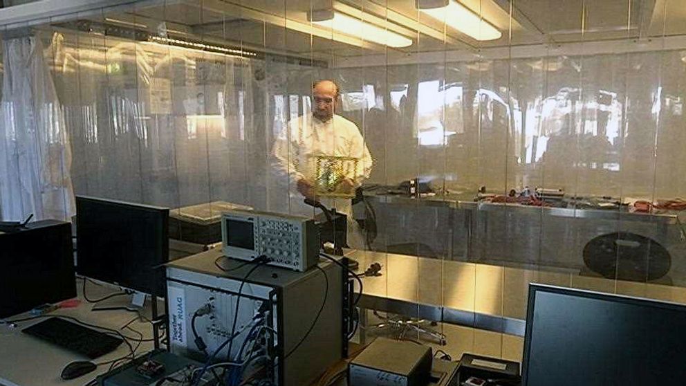 En man bär på ett föremål inne i ett laboratorium.