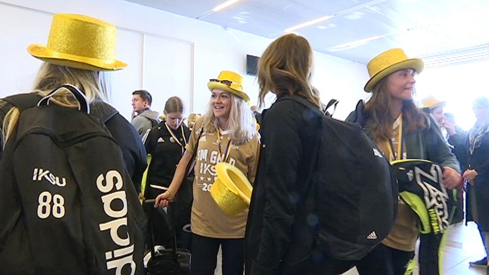 tjejer i guldhattar på flygplatsen