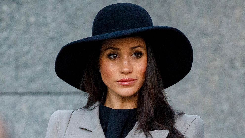 Meghan Markle i svart hatt ser allvarlig ut.