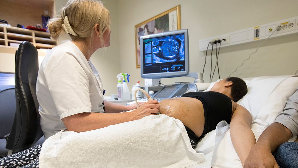 Kvinna som gör ultraljud och barnmorska.
