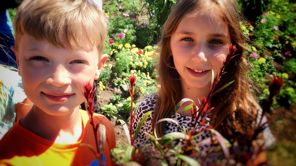 två barn med blomsterarrangemang.
