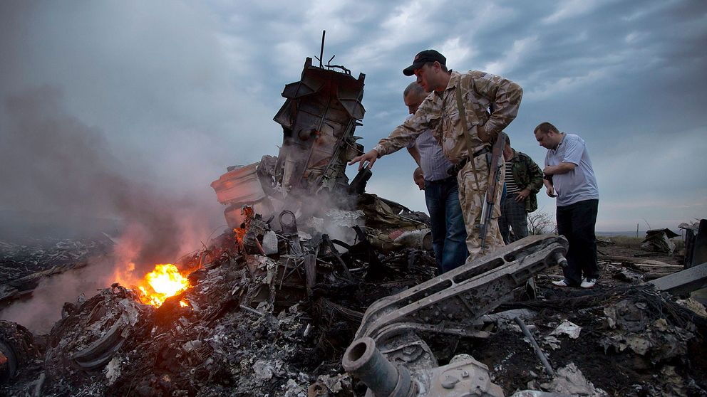 Människor undersöker vraket från planet MH17 i Ukraina i juli 2014.