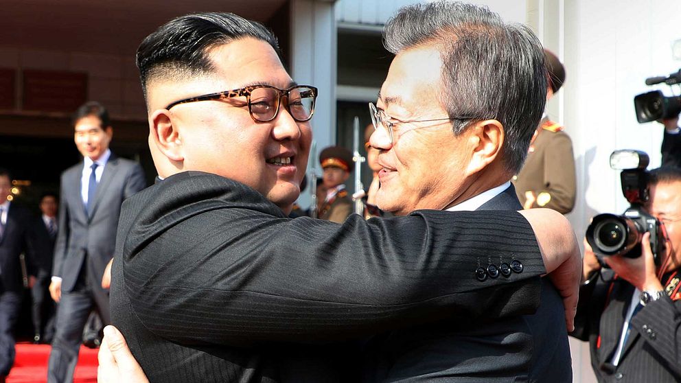 Nordkoreas ledare Kim Jong Un och Sydkoreas president Moon Jae-In kramar varandra inför en samling fotografer.