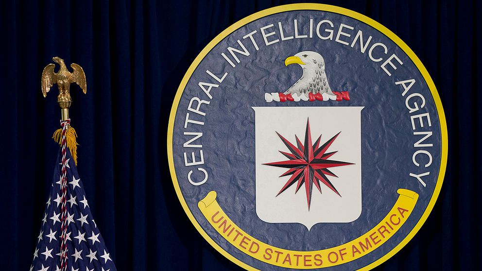 CIA:s vapensköld bredvid en amerikansk flagga.
