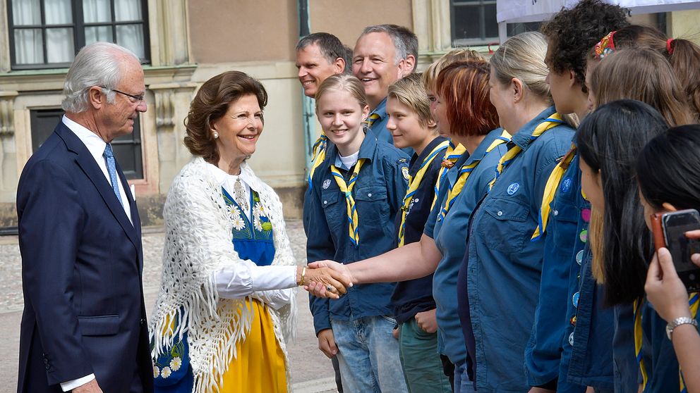 Kung Carl Gustaf och drottning Silvia hälsar på medlemmar ur Bergshamra scoutkår, under nationaldagsfirandet på Stockholms slott.