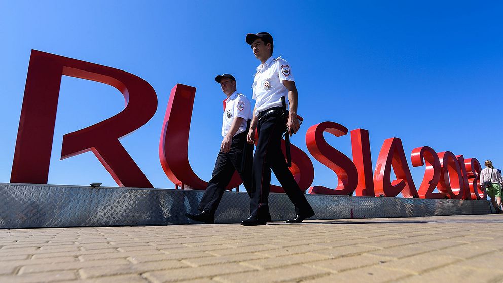 Två poliser går framför VM-skylten.