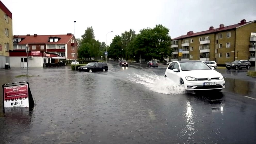 En bil som kör genom på en vattendränkt väg.