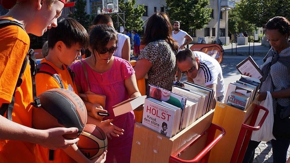 Barn och ungdomar spelar basket och läser böcker under en sommarlovssatsning.