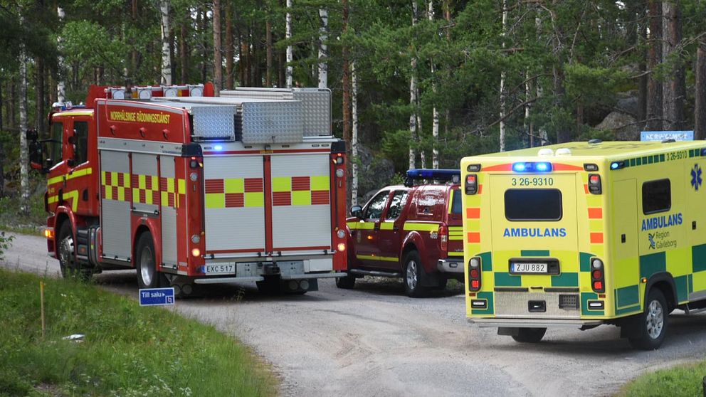 Ambulans och räddningstjänst står på en grusväg.