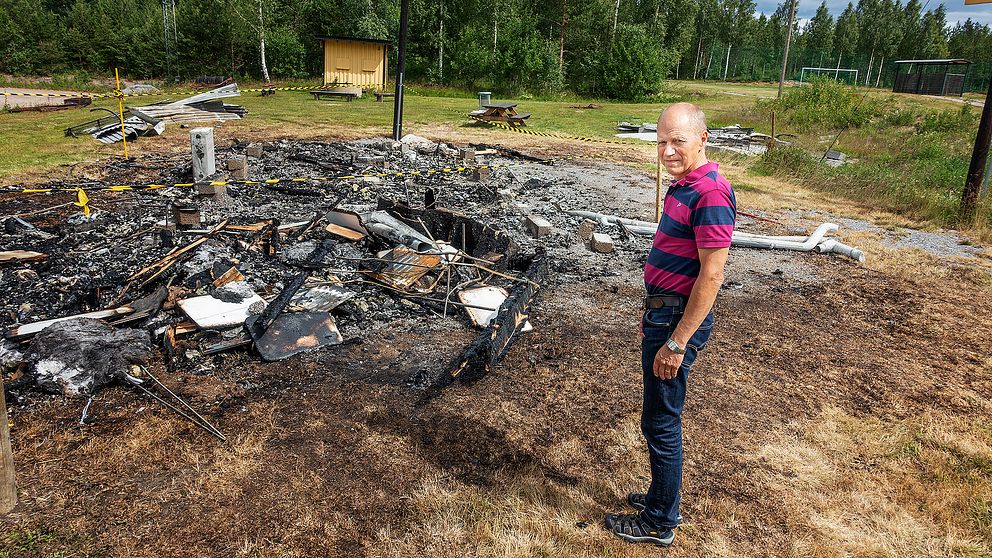 Anders Björkman, ordförande i Enångers IK, ser på resterna efter den nyss återuppbyggda tidtagarstugan, som har brunnit igen.