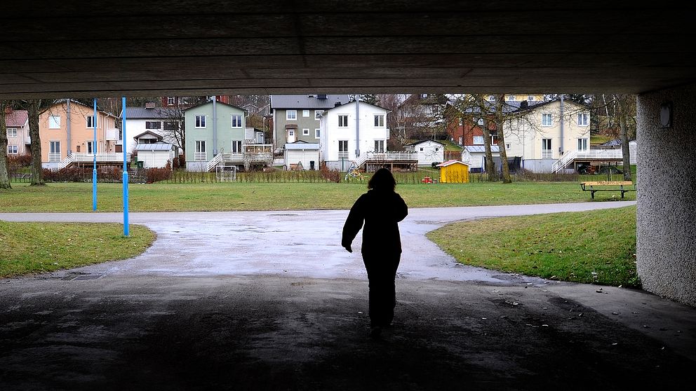 Bild på en kvinna som promenerar i en tunnel.