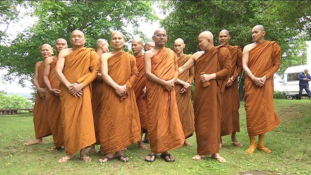 en grupp män med rakade huvuden, klädda i  buddhistisk munk-svepning