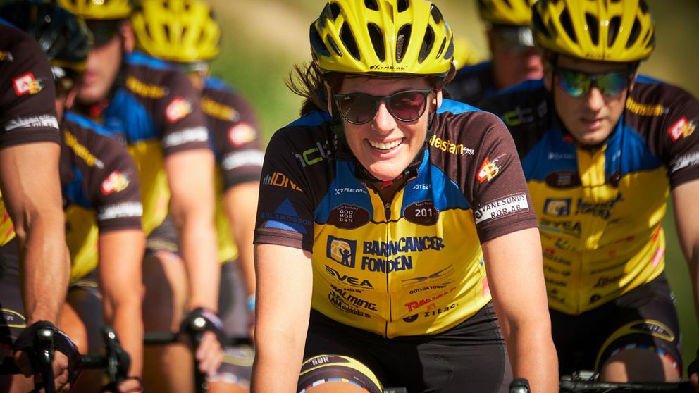 En bild på Johanna Stigmar som cyklar, med fler cyklister i bakgrunden.