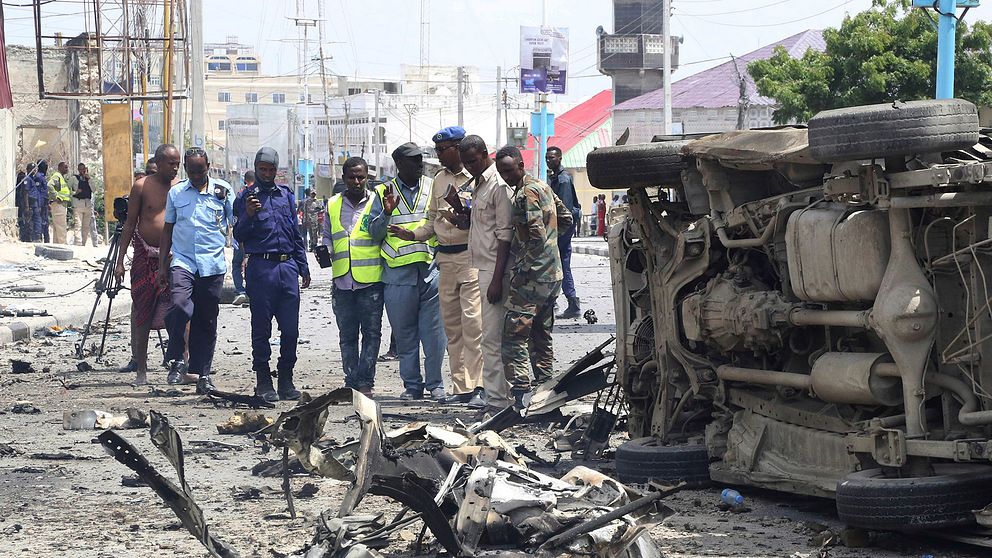 Somaliska säkerhetsstyrkor vid en bil som förstörts i explosionerna.