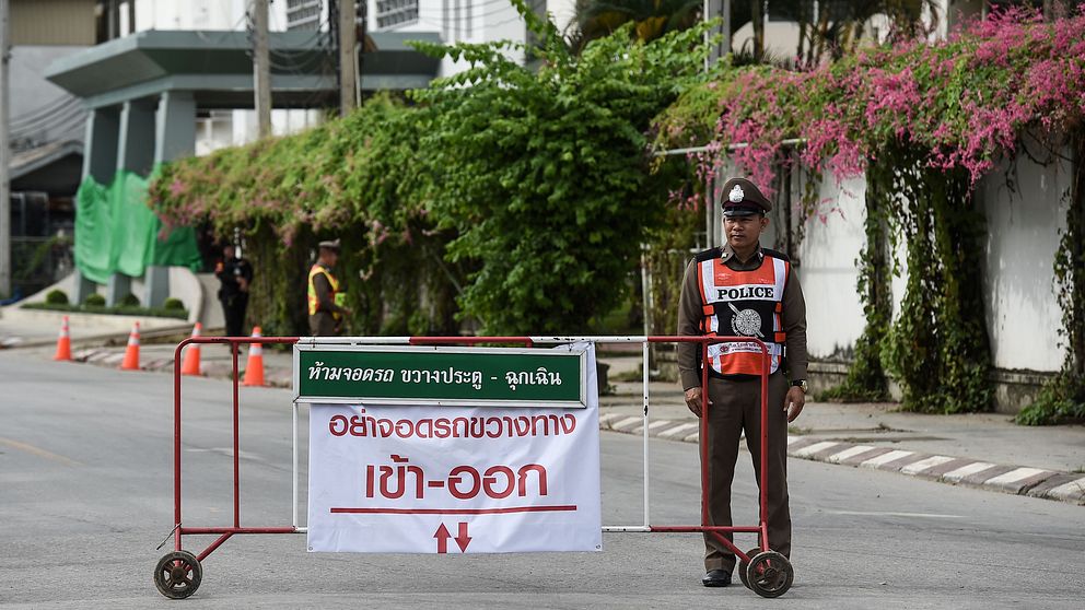 En polis vaktar utanför sjukhuset i Chiang Rai där pojkfotbollslaget nu hålls isolerade efter att ha räddats ur grottan.
