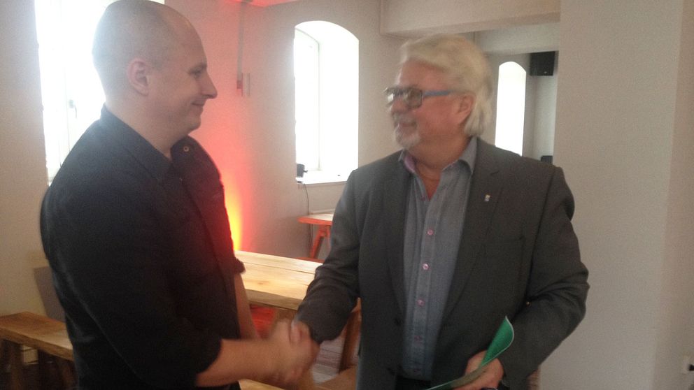 Nicklas Platow tar i hand med näringslivschef Thorbjörn Lind efter överenskommelsen om Karön.