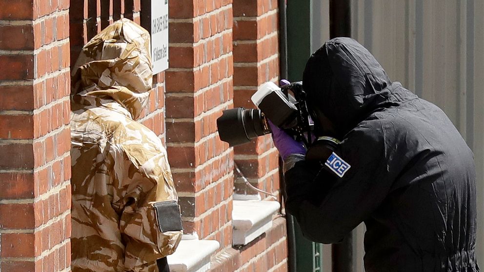 Polis i skyddsutrustning som utreder var giftet kan ha kommit ifrån som dödade en kvinna och förgiftade hennes partner.