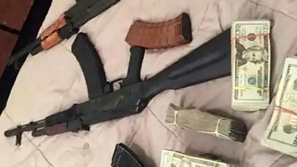 En bild från polisens förundersökning på pengar och skjutvapen på vad som ser ut att vara ett sängöverkast.