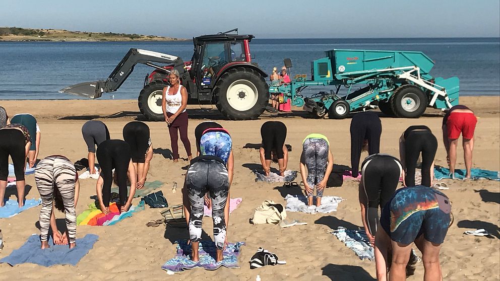 Här kör strandrensaren på Tylösand förbi ett pågående yoga-pass.