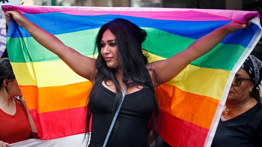 En kvinna i Libanon håller upp en regnbågsflagga.