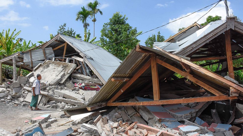 En man inspekterar skadorna på ett hus efter jordskalvet på ön Lombok.