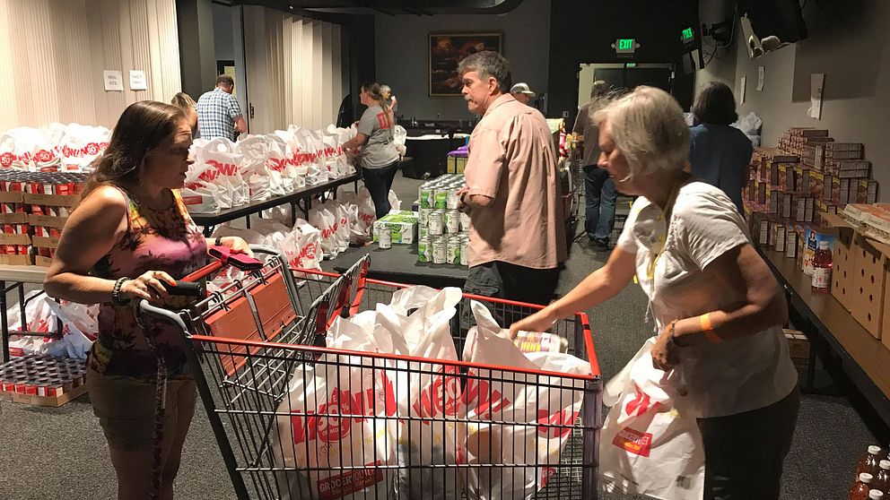 Människor som går med shoppingvagn och hämtar varor efter att ha drabbats av branden.