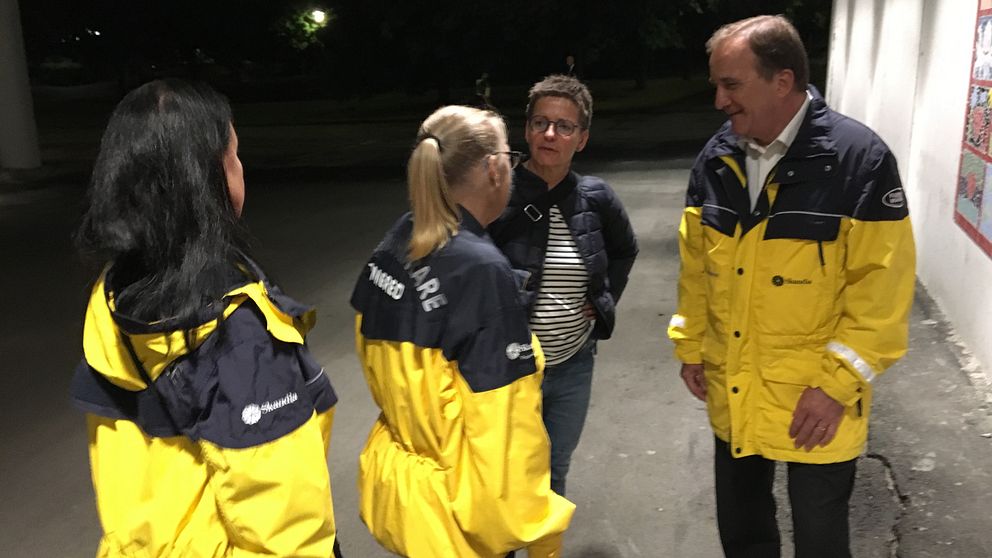 Löfven och Hermansson tillsammans med nattvandrare i gula jackor.