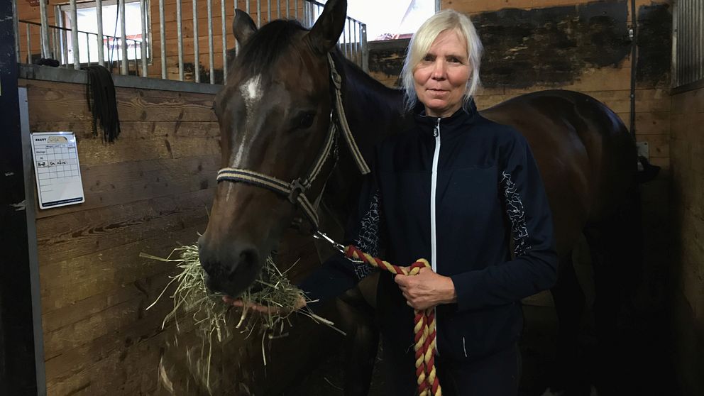 Ridhuschef Lotta Andersson med häst som äter hö