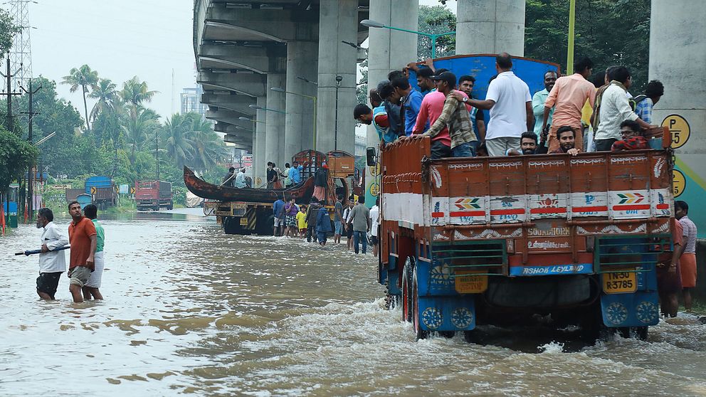 Folk åker med en lastbil till en evakueringsplats för att undkomma de kraftiga översvämningarna i staden Kochi