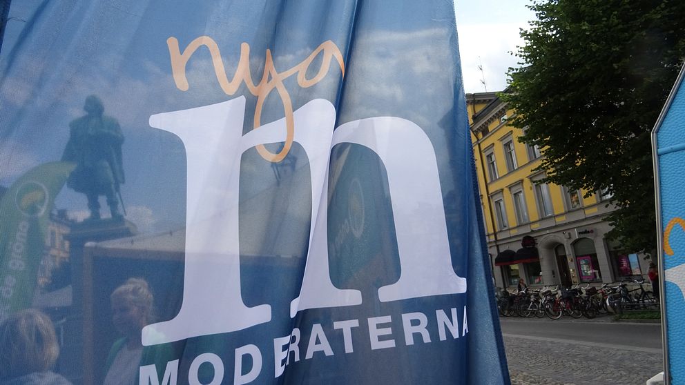 Moderaternas logotype på flagga på Stortorget i Örebro. Engelbrektsstatyn syns igenom.