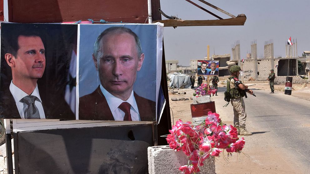 Ryska och syriska styrkor står på vakt i Idlib-provinsens östra utkant, där porträtt på syriske och ryske presidenterna hängts upp.