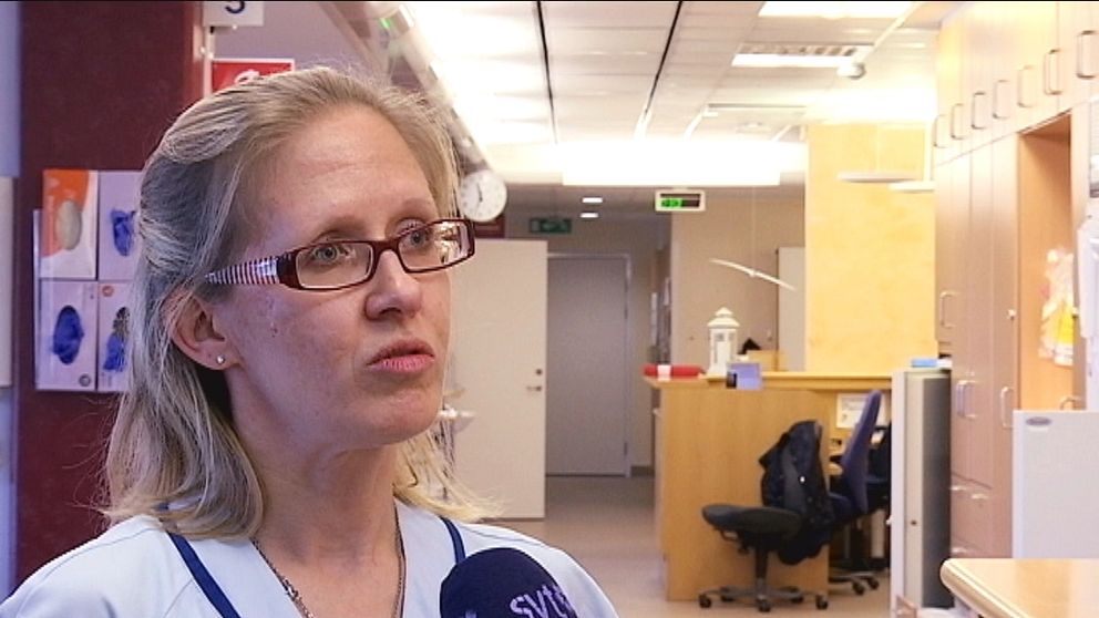 Porträttbild på sjuksköterskan Annki Svedberg som står i en sjukhuskorridor.