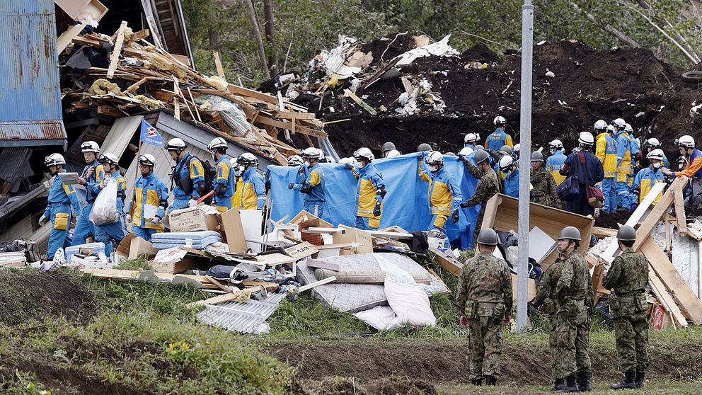Poliser och militär bär ut saknade människor som hittats i drabbade områden efter jordskalvet i torsdags.