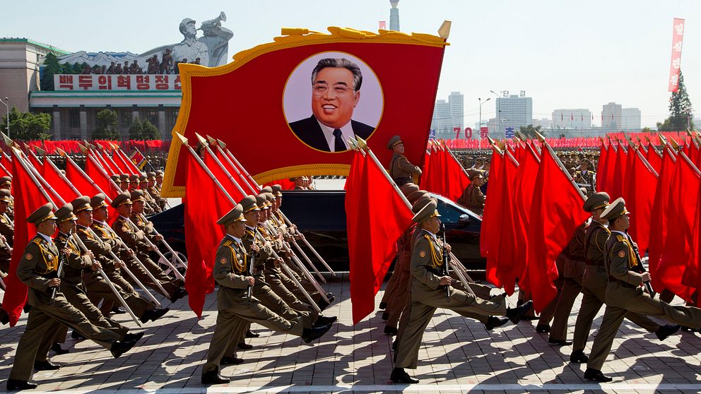 Foto på koreanska soldater i paraden på 70-års jubileumet för Nordkorea. På bilden syns även en bild i paraden på Nordkoreas högsta ledare Kim Jong-Un