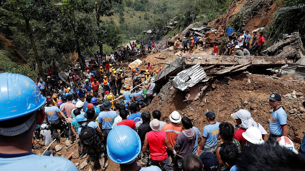 Människor hälps åt i en räddningsinsats för att leta efter gruvarbetarna i Itogon, som sitter fast efter ett jordskred som orsakats av regnet.