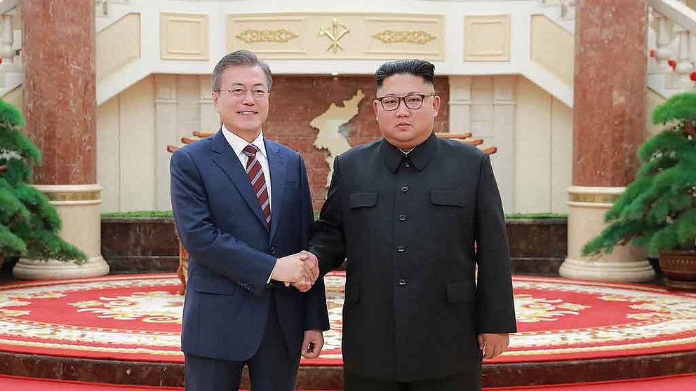 Sydkoreas Moon Jae-In och Nordkoreas Kim Jong-Un skakar hand.