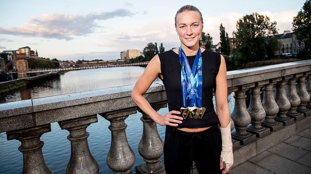 Sarah Sjöström visar stolt upp sina fyra EM-guld i Glasgow, nu kanske hon väljer den penningstinna världscupavslutningen i stället för guldjakt i kortbane-VM
